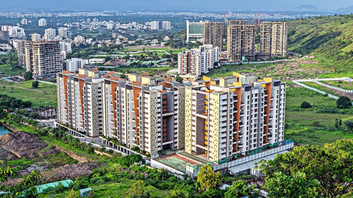 Image of tall buildings under construction near the hill in Pune, Maharashtra.