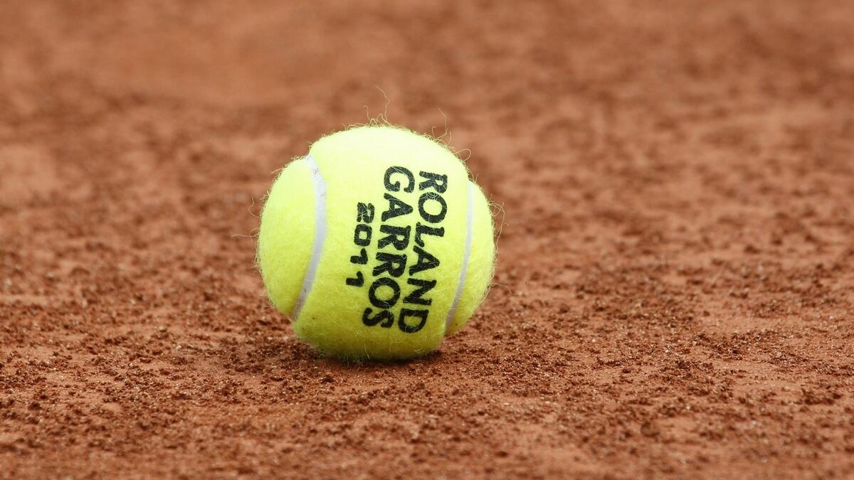 A tennis ball is seen on the clay at the Roland Garros stadium in Paris. The French Open begins Sunday