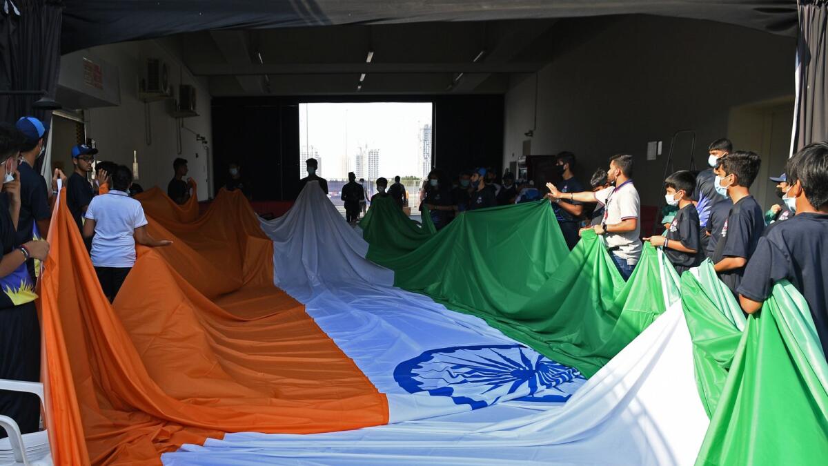 Flag boys hold India's national flag as they rehearse before the start of the ICC men’s Twenty20 World Cup cricket match between India and Pakistan at the Dubai International Cricket Stadium in Dubai on October 24, 2021. (Photo: AFP)