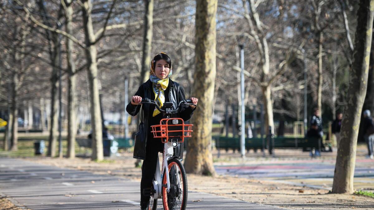 Afghan refugee and activist for women's rights Fatima  AFPHaidari poses for a photo riding a bicycle in a park in Milan, Italy, on February 7, 2023. —
