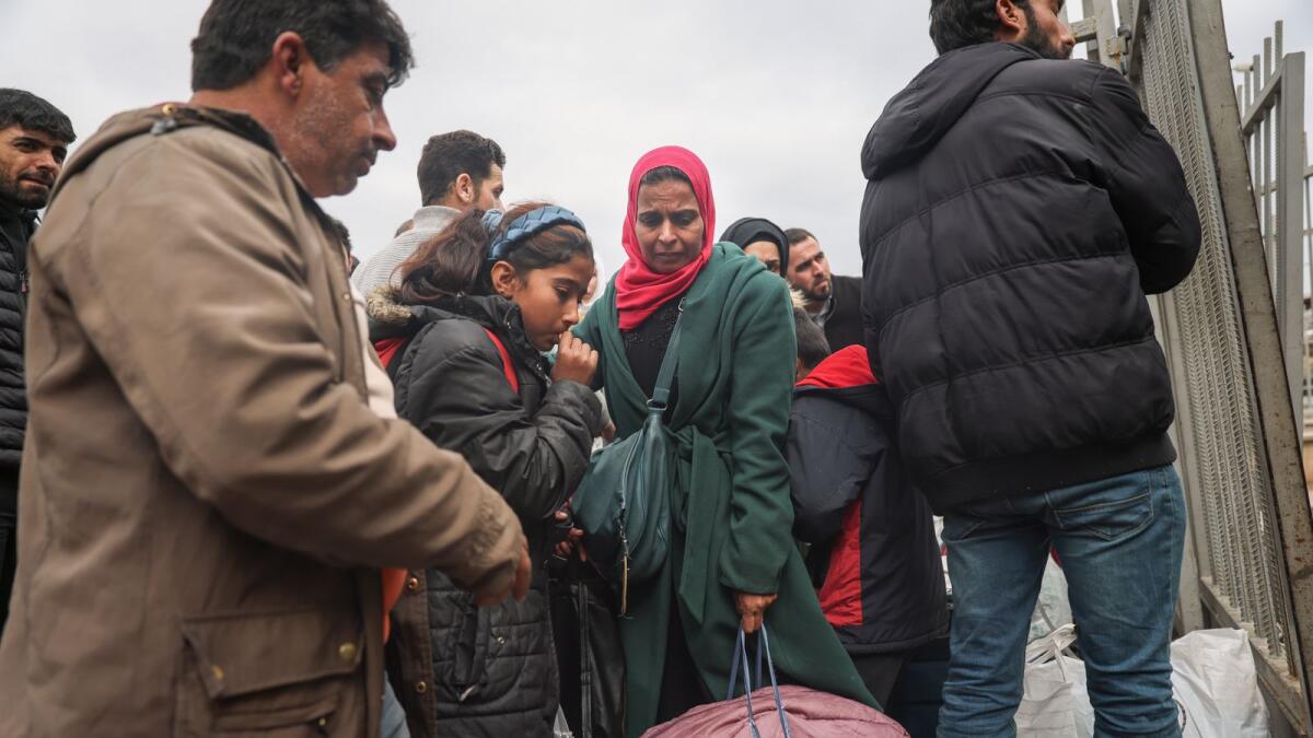 Syrians wait to cross into Syria from Turkey at the Cilvegozu border gate, near the town of Antakya, southeastern Turkey. — AP