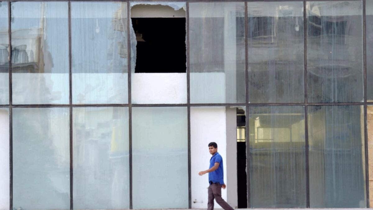 Shattered glass in front of the building where a wanted person blew himself up while being arrested by security forces in Jeddah. — AFP