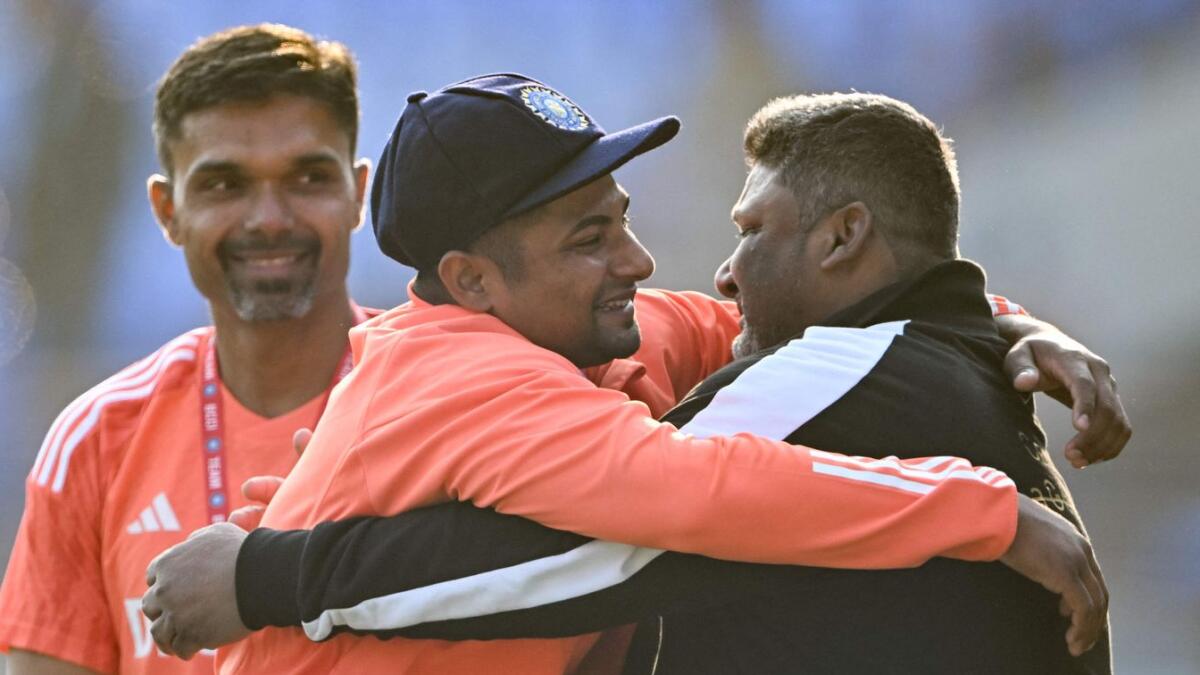 India's Sarfaraz Khan (C) greets his father, Naushad Khan, before his debut match at the Niranjan Shah stadium in Rajkot on February 15. - AFP-