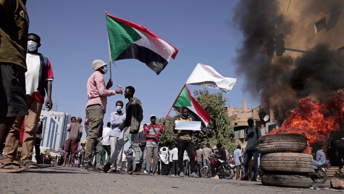 People chant slogans and burn tires during a protest to denounce the October 2021 military coup, in Khartoum, Sudan. — AP