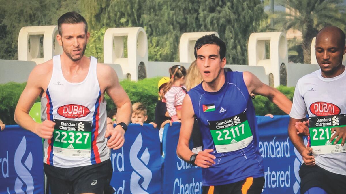 James Gibb and Maekele Asfha run as pacer and guide with blind runner Hasan Tayem at the 2019 Dubai Standard Chartered Marathon