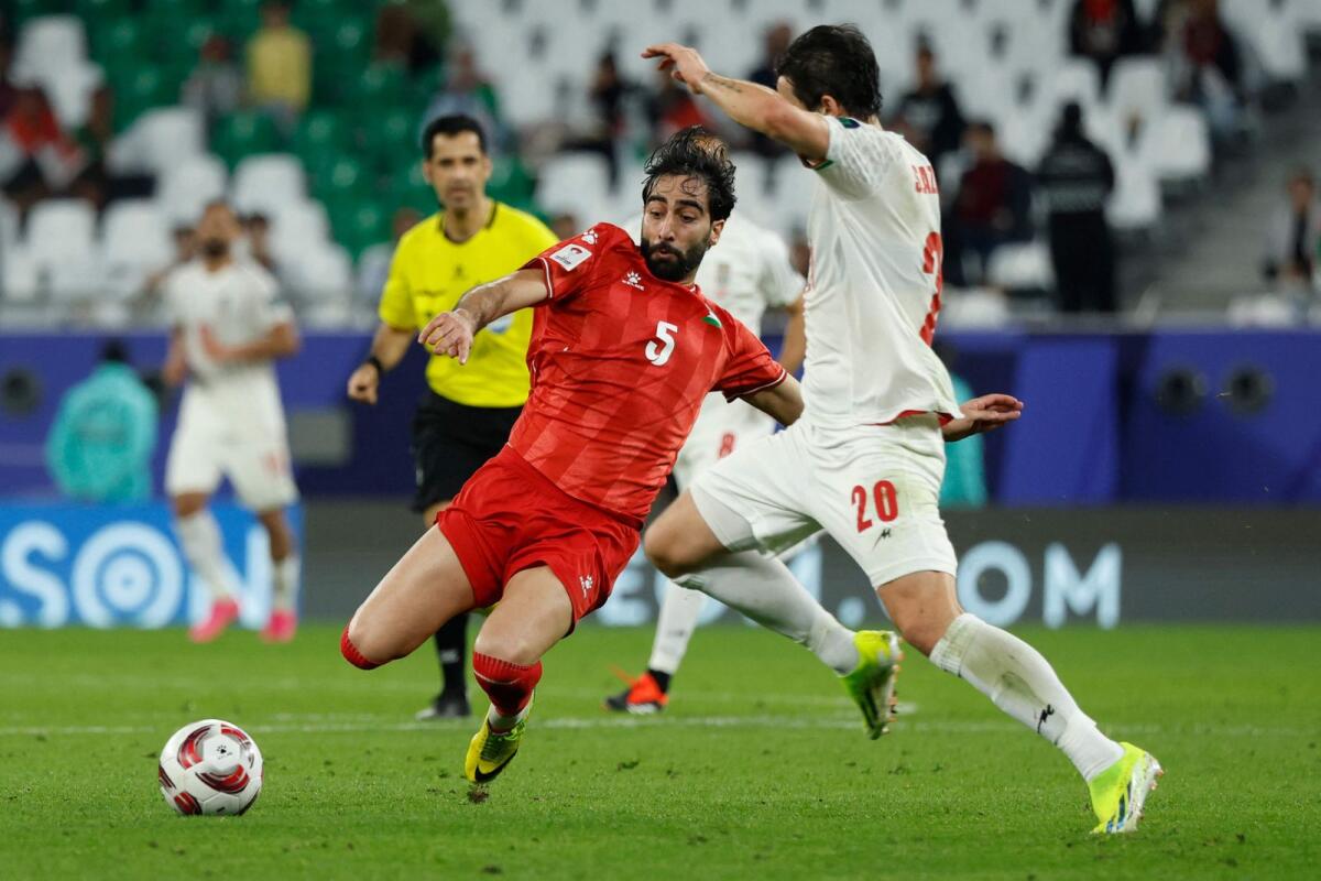 Palestine's defender Mohammed Saleh and Iran forward Sardar Azmoun vie for the ball during the Asian Cup match. — AFP