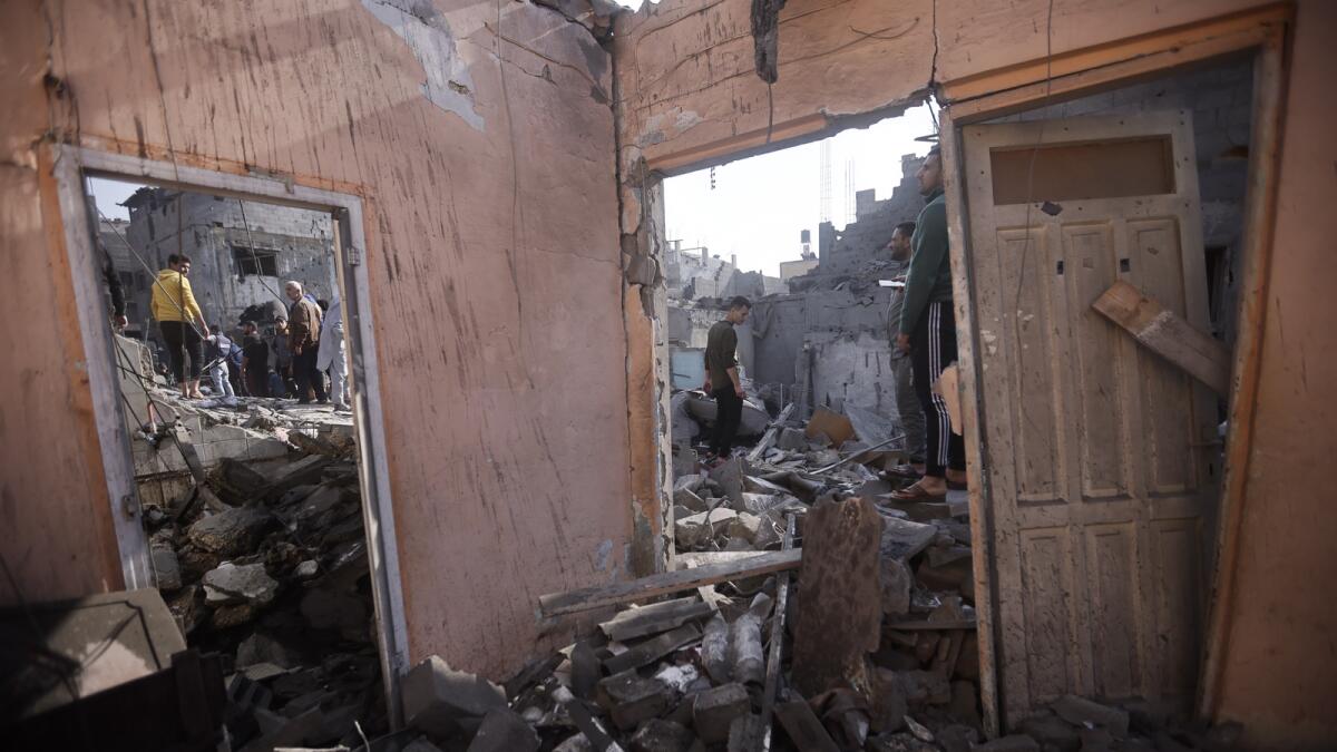 Palestinians look at destruction after the Israeli bombing In Khan Younis refugee camp in Gaza Strip. - AP