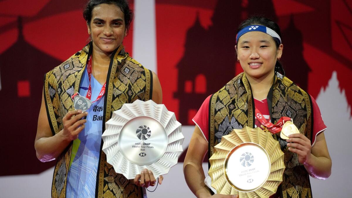An Se-young of South Korea and PV Sindhu of India pose with their trophies. (AP)