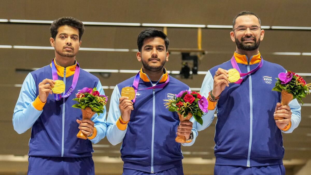 Indian shooters Swapnil Suresh Kusale, Aishwary Pratap Singh Tomar and Akhil Sheoran pose with their gold medal during the presentation ceremony of men's 50m rifle 3 positions team event. - PTI