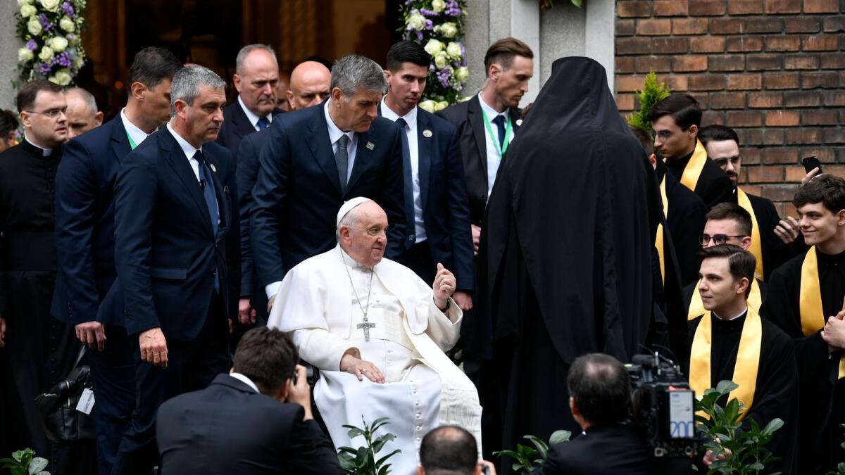 Pope Francis leaves church after a meeting with a Greek Catholic community  in Budapest, Hungary, on Saturday. The Pontiff is in Hungary for a three-day pastoral visit. — AP