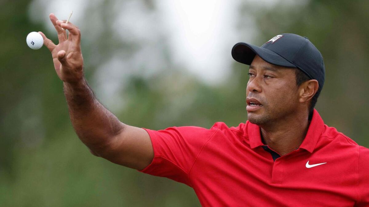 Tiger Woods catches a golf ball on the course. - AFP File