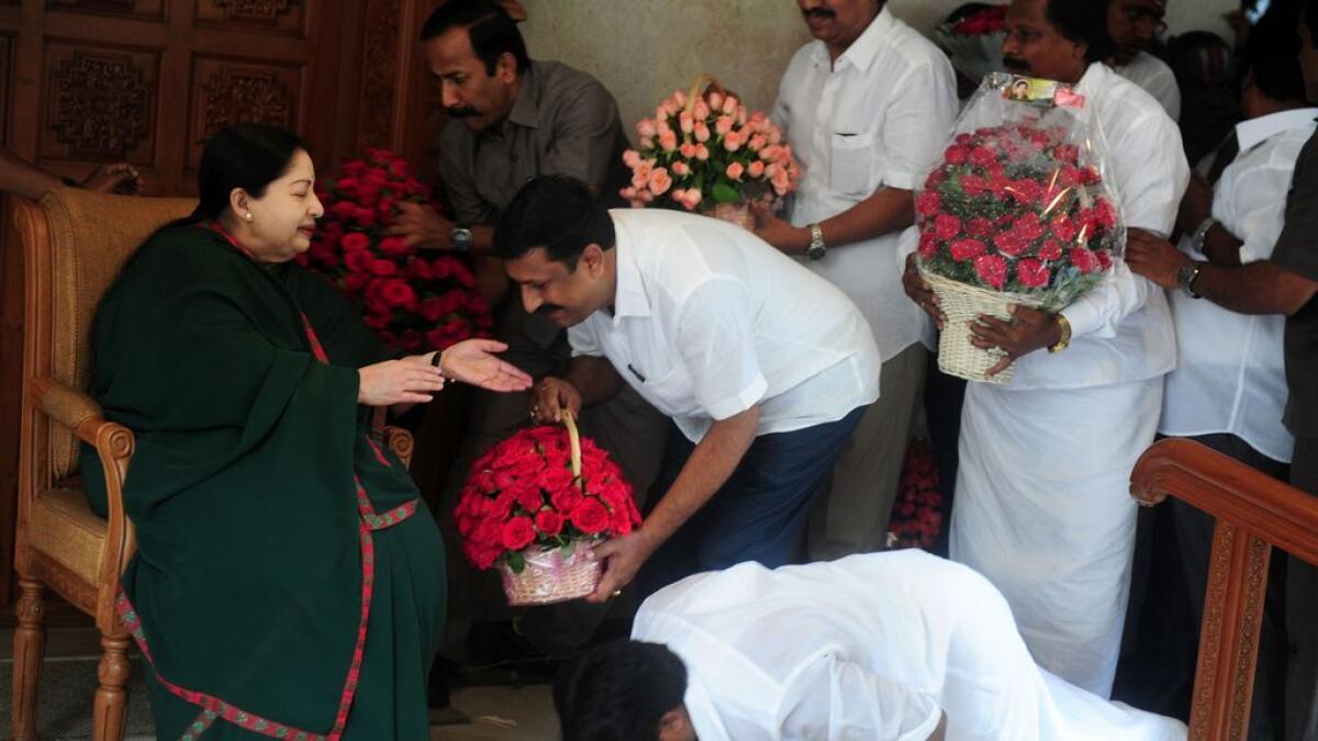 A party cadre prostrates himself at the feet of All India Anna Dravida Munnetra Kazhagam(AIADMK) leader Jayalalithaa Jayaram as she gestures at her residence in Chennai 