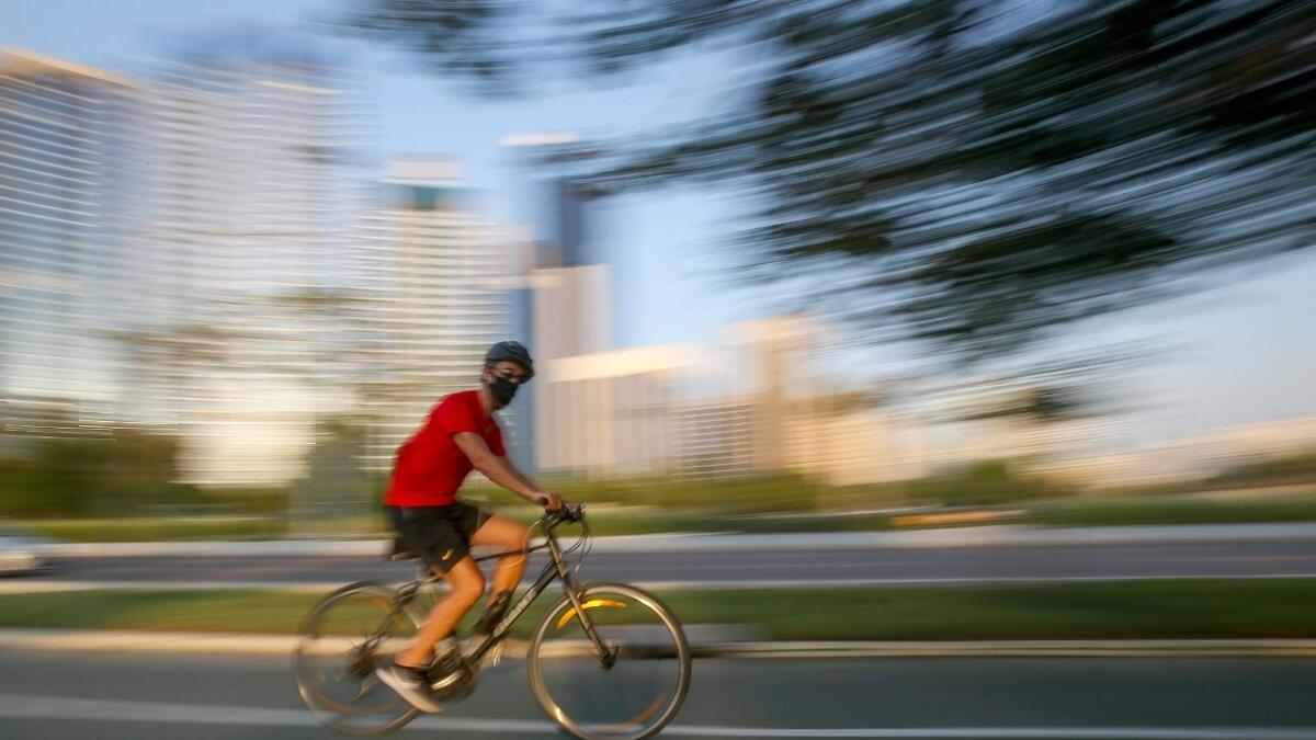 A resident wearing protective mask ride on his bike along the corniche in Abu Dhabi.  Photo by Ryan Lim/Khaleej Times