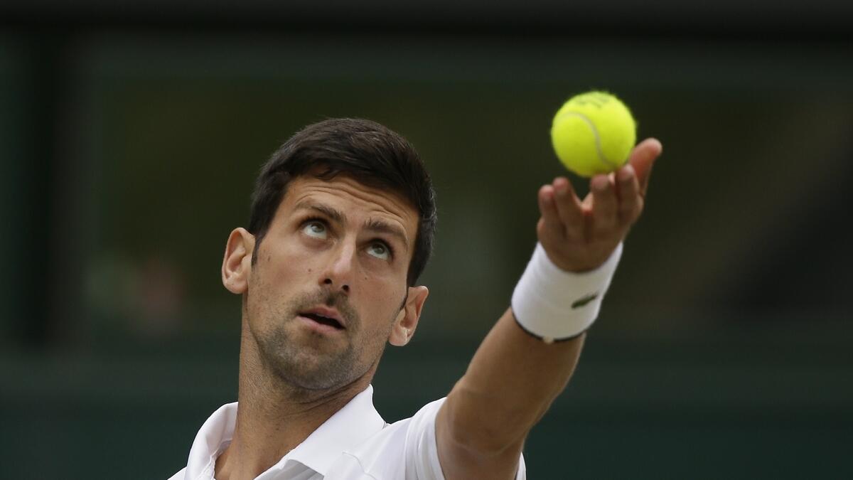 Novak Djokovic serves to Roger Federer during the men's singles final match of the Wimbledon Tennis Championships in London. AP
