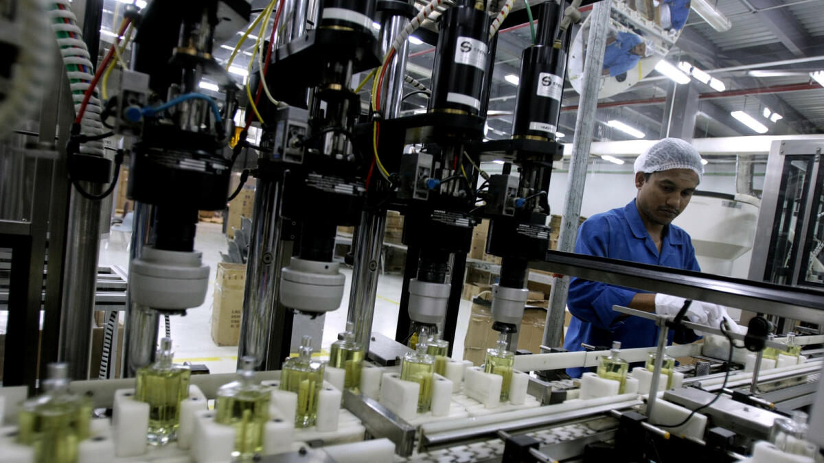 A worker bottles perfume at a Dubai factory. — AFP file