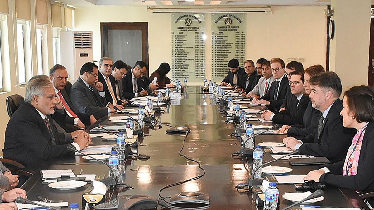 Ishaq Dar (L) meeting with a International Monetary Fund (IMF) review mission led by Nathan Porter (2R) at the Finance Ministry in Islamabad. — AFP