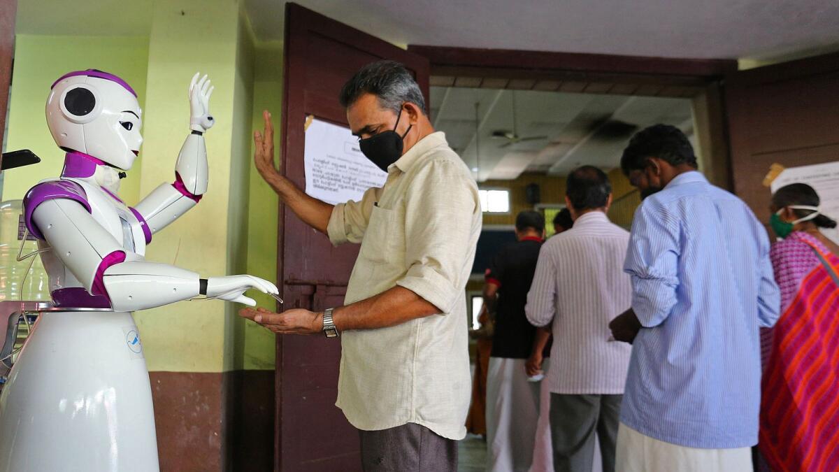 Robot dispensing sanitizer at polling booth in Kochi. Photo: AFP
