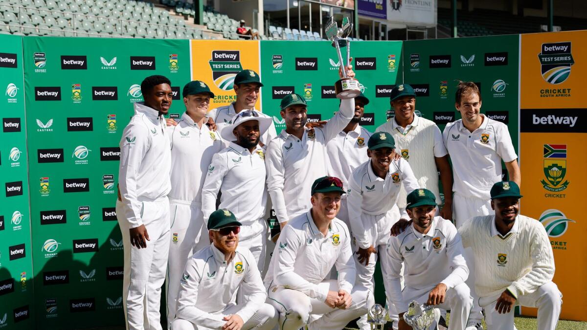South Africa's Dean Elgar (centre) holds the trophy as the South African team pose for a photo after winning the Test series. (AFP)