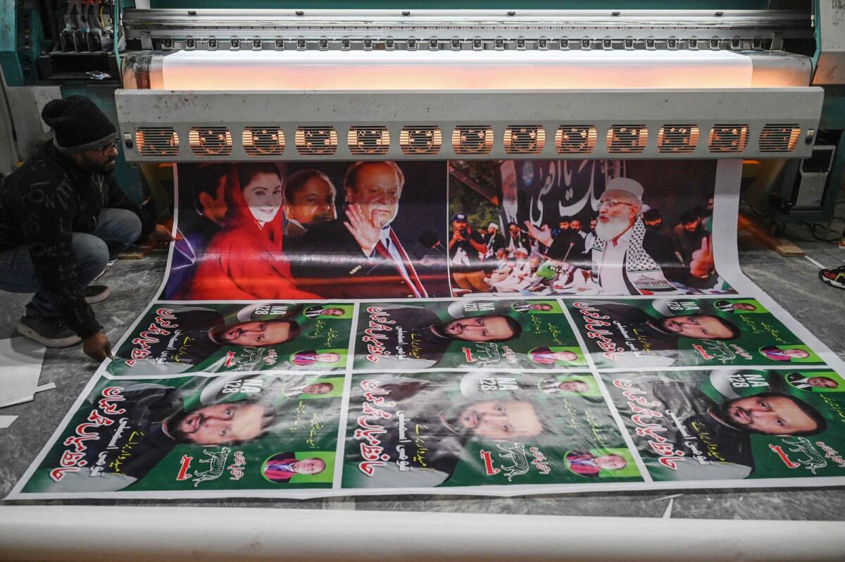 A worker prints election campaign posters of Pakistan's former prime minister Nawaz Sharif (top 3L) and his daughter Maryam Nawaz (top L) at a printer in Lahore on January 9, 2024, ahead of the upcoming general elections. — AFP
