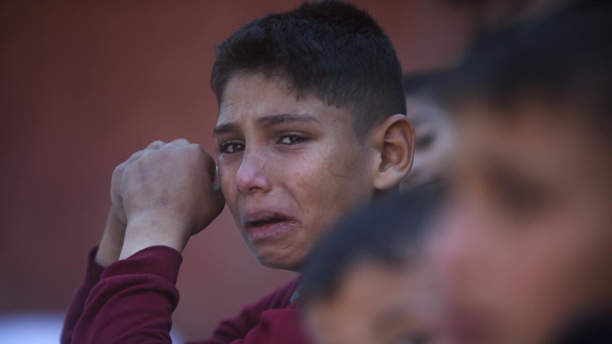 A Palestinian boy cries for his relatives who were killed in the Israeli bombardment of the Gaza Strip on December 15. — Photo: AP