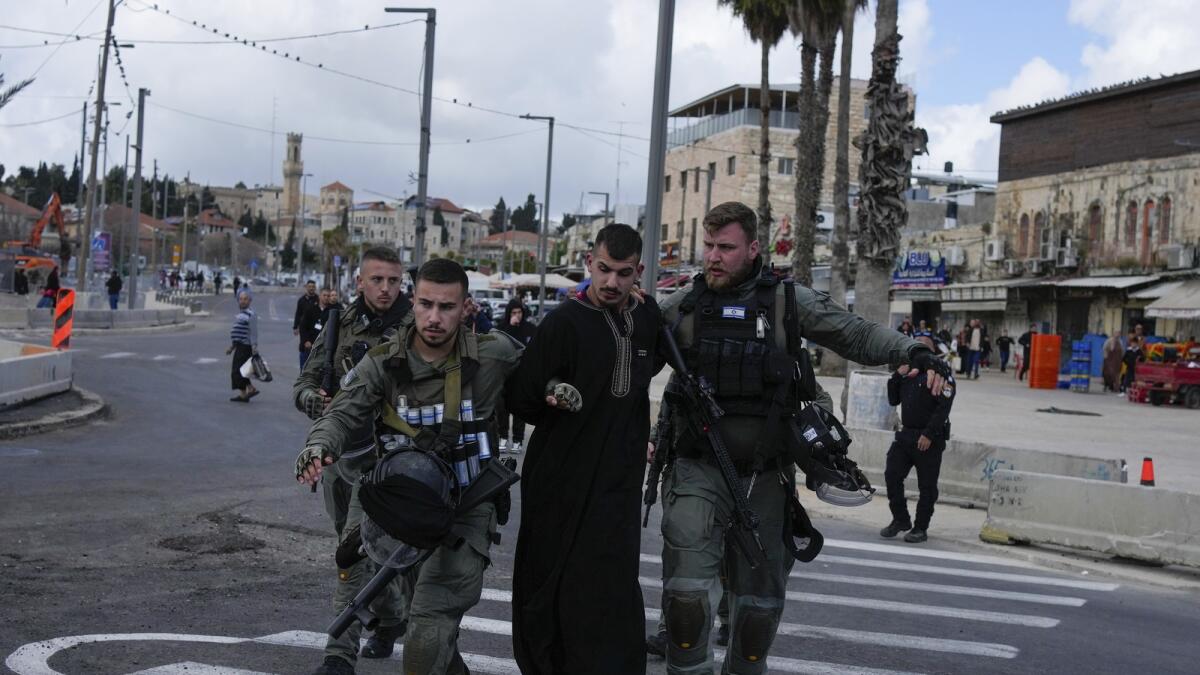 Israeli security forces detain a Palestinian man just outside Jerusalem's Old City. — AP