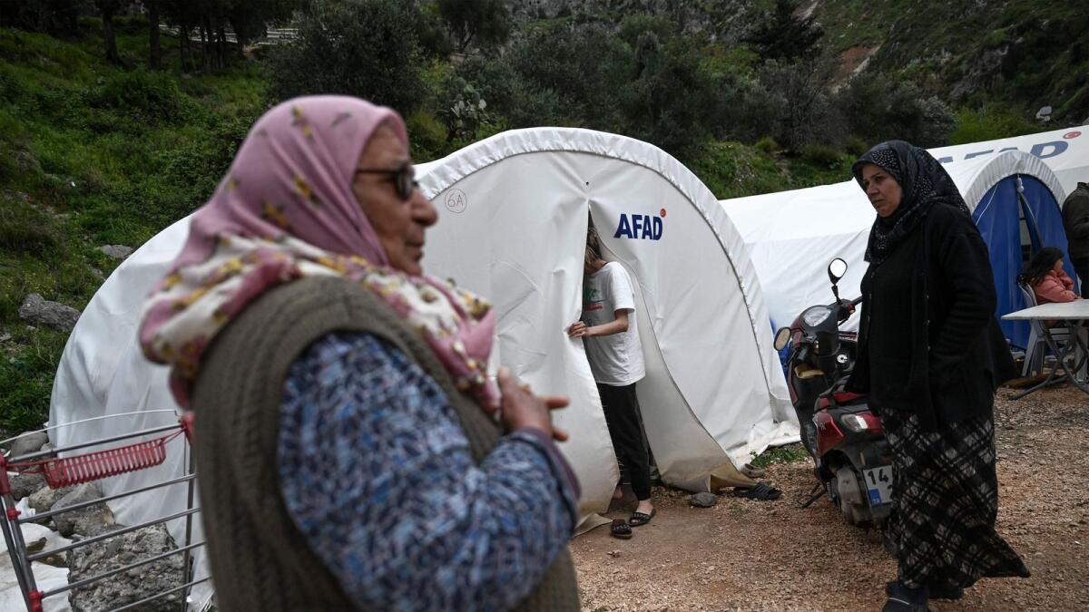 Hatice Yurtsever (L) and other women stand outside tents at a camp, two months after a 7.8-magnitude jolt and its aftershocks wiped out swathes of Turkey's mountainous southeast in Antakya on Thursday. --AFP