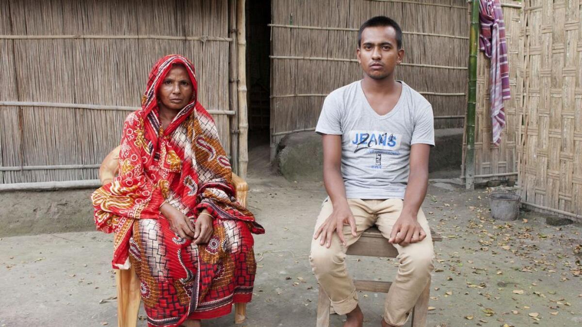 Bangladeshi villager Fatema Khatun (L), 45, and her son Bulbul Islam, 15, pose for a photograph at her home in the border town of Debiganj.  