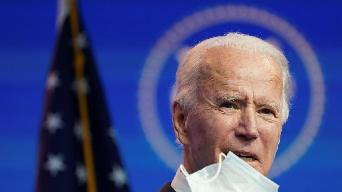 US President-elect Joe Biden holds up a face mask as he speaks about the US economy in Wilmington, Delaware, US, November 16, 2020.