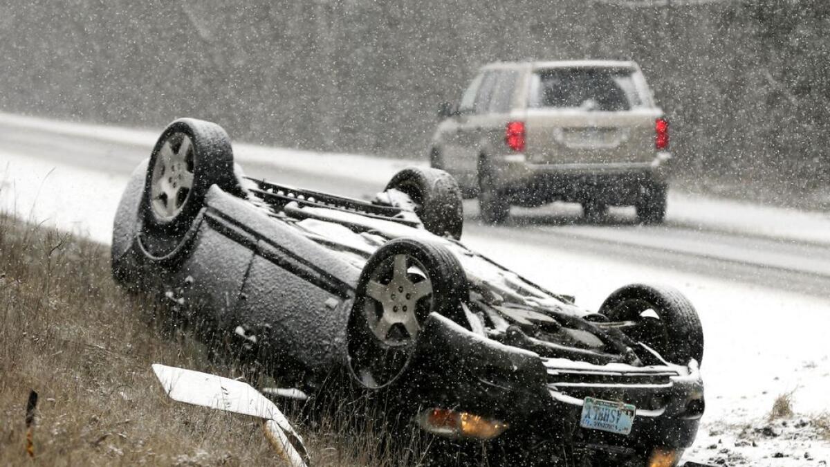 An overturn vehicle rests on the shoulder of a snow-covered U.S. 522 near Gainesboro, V.- AP