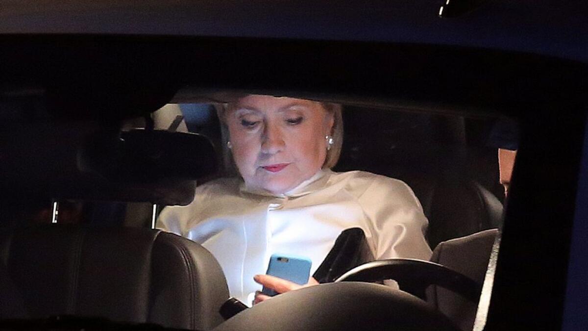Democratic nominee Hillary Clinton looks at her mobile phone as she leaves her house to attend Congressional Black Caucus Foundation's Phoenix Awards Dinner in Washington. -Reuters 