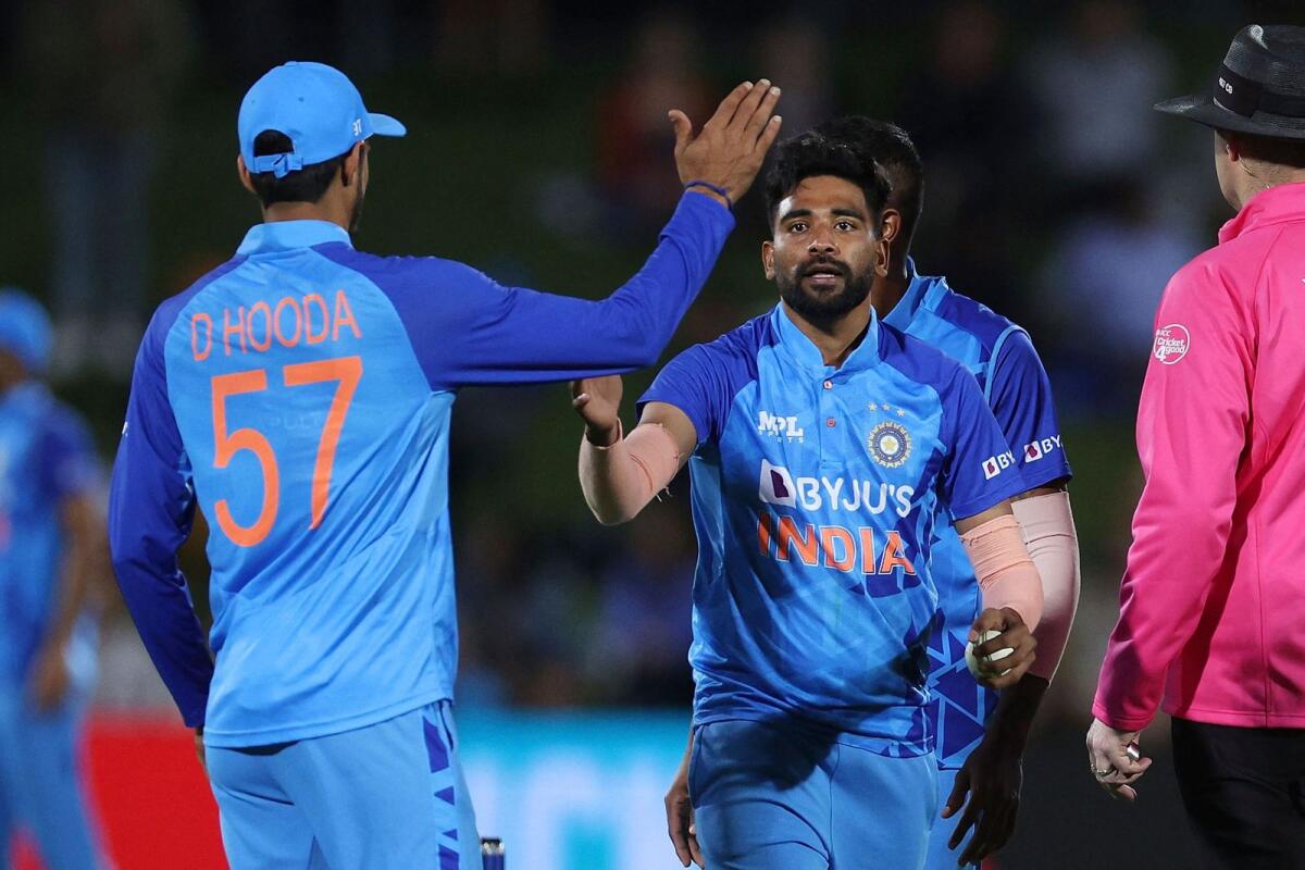 India’s Mohammed Siraj (centre) celebrates the wicket of New Zealand's Mitchell Santner with teammate Deepak Hooda (left) in Napier on Tuesday. — AFP
