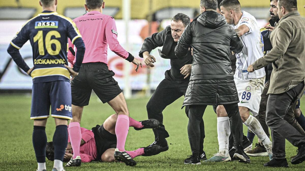 The referee, who fell to the ground, was also kicked in a melee. Photo X