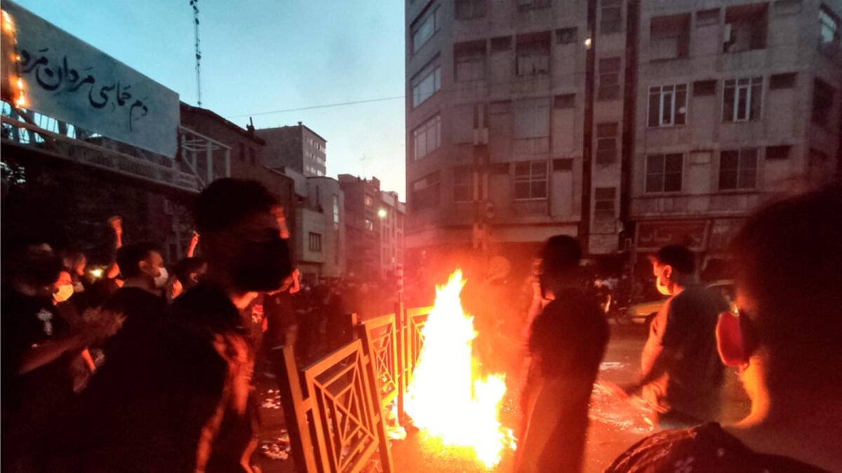 Protesters make fire and block the street over the death of Mahsa Amini in downtown Tehran. — AP