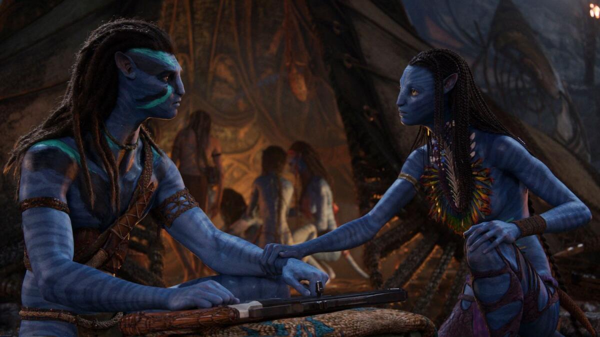 Jake Sully, voiced by Sam Worthington, left, and Neytiri, voiced by Zoe Saldana in a scene from Avatar: The Way of Water