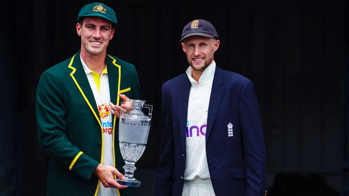 Australia captain Patrick Cummins (left) and England skipper Joe Root pose with the Ashes trophy in Brisbane on Sunday. (AFP)
