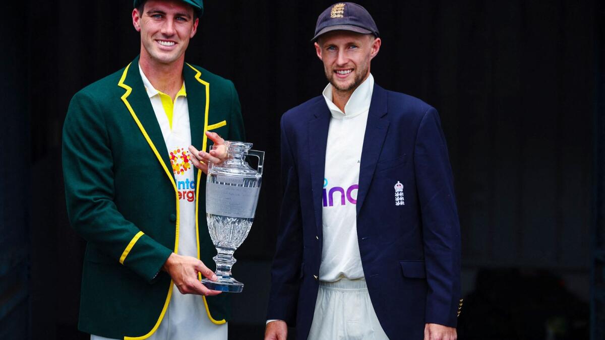 Australia captain Patrick Cummins (left) and England skipper Joe Root pose with the Ashes trophy in Brisbane on Sunday. (AFP)