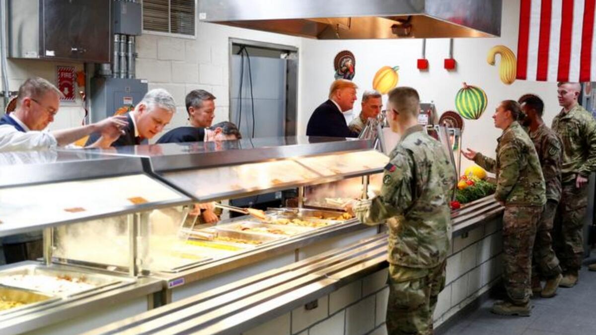 President Donald Trump serves food to US troops at a Thanksgiving dinner event during a surprise visit at Bagram Air Base in Afghanistan. - Reuters