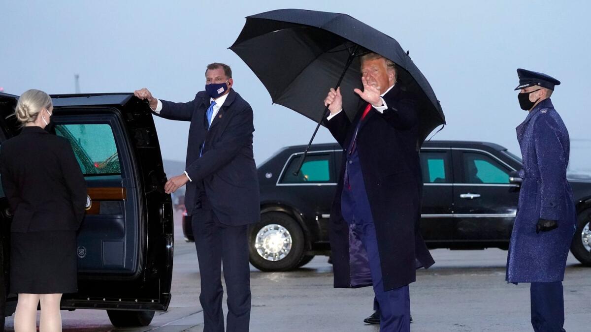 President Donald Trump waves as he steps off Air Force One upon arrival on October 25, 2020, at Andrews Air Force Base, Md.