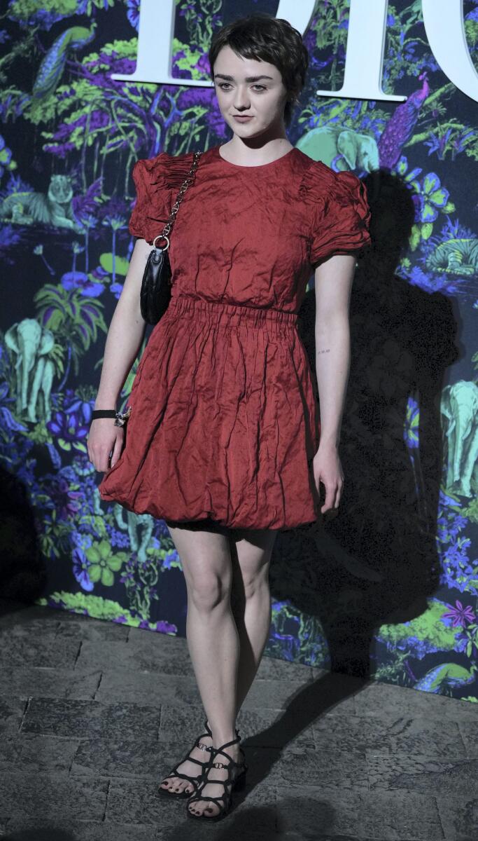 'Game of Thrones' actress Maisie Williams dressed in a red crinkled dress with puffer sleeves. She opted a pair of black strappy heels and a matching black bag.