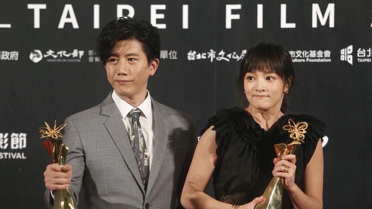 Taiwanese actress Gingle Wang, right, and Taiwanese actor Mo Tzu-yi hold their awards for Best Actress and Best Actor at the 2020 Taipei Film Festival in Taipei, Taiwan, Saturday, July 11, 2020. The 2020 Taipei Film Festival is the world's first large-scale film festival held by an entity after the outbreak of the Covid-19 epidemic. AP