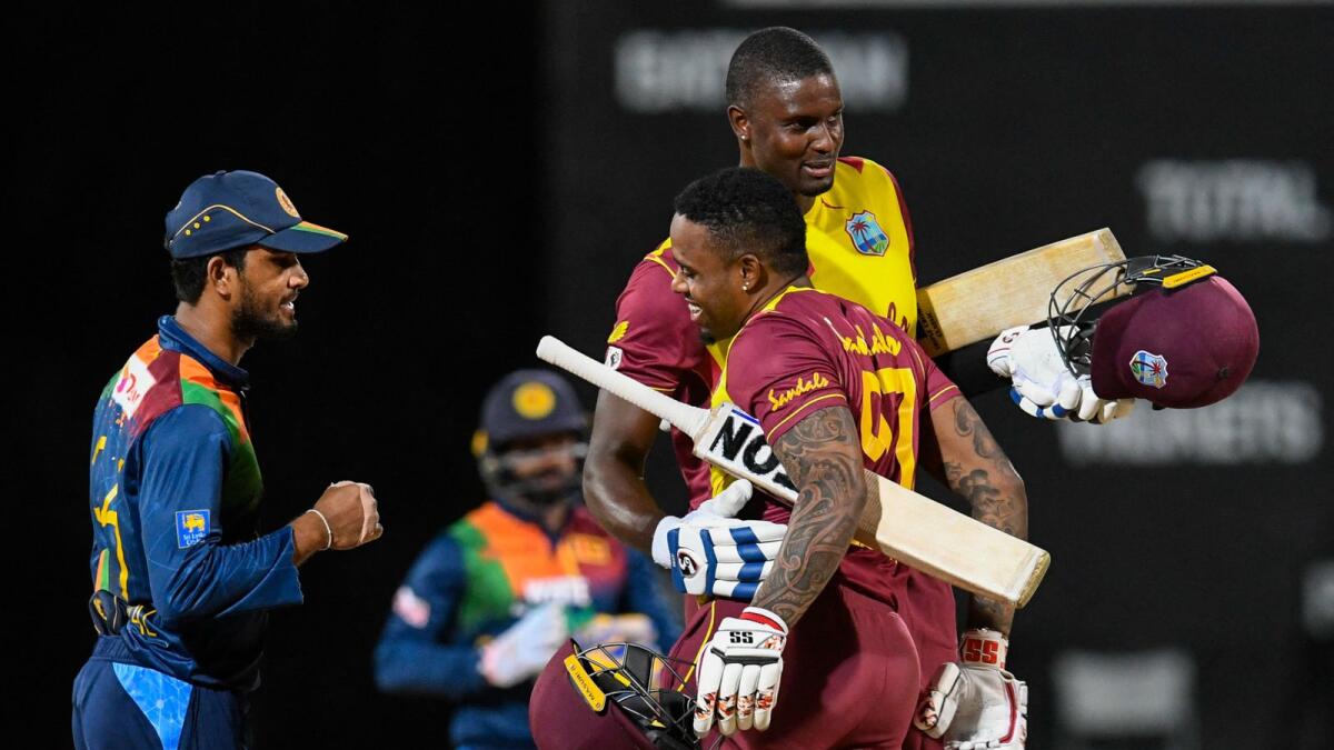 Dinesh Chandimal (left) of Sri Lanka watch as Fabian Allen (centre) and Jason Holder of West Indies celebrate winning the 3rd and final T20I match.— AFP