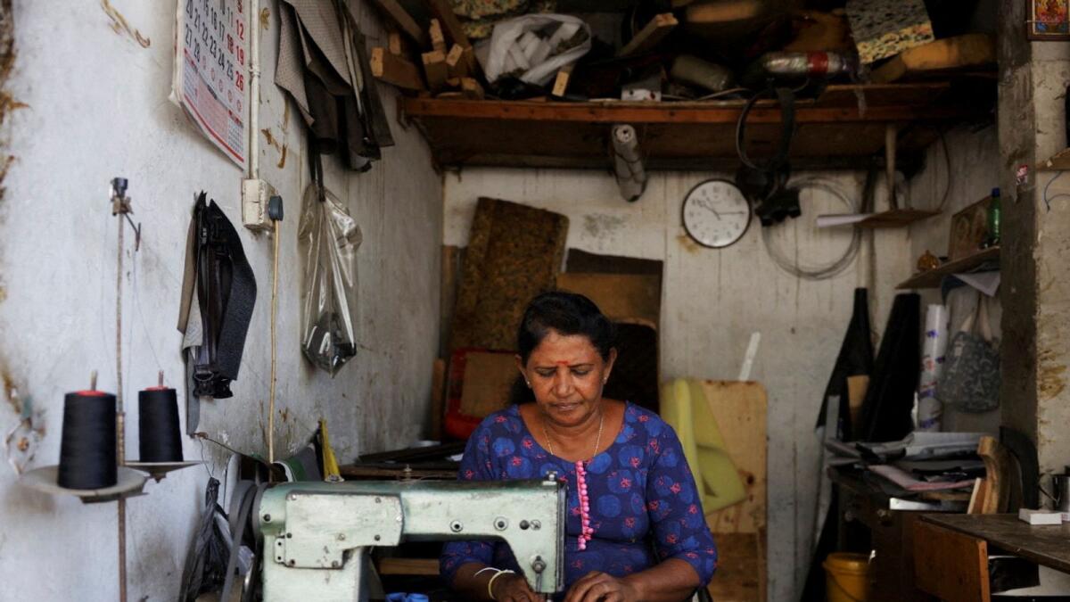 A woman uses an electric sewing machine at her shop, after the government announced a hike in power prices by 66 per cent in Colombo, Sri Lanka, on Thursday. - Reuters