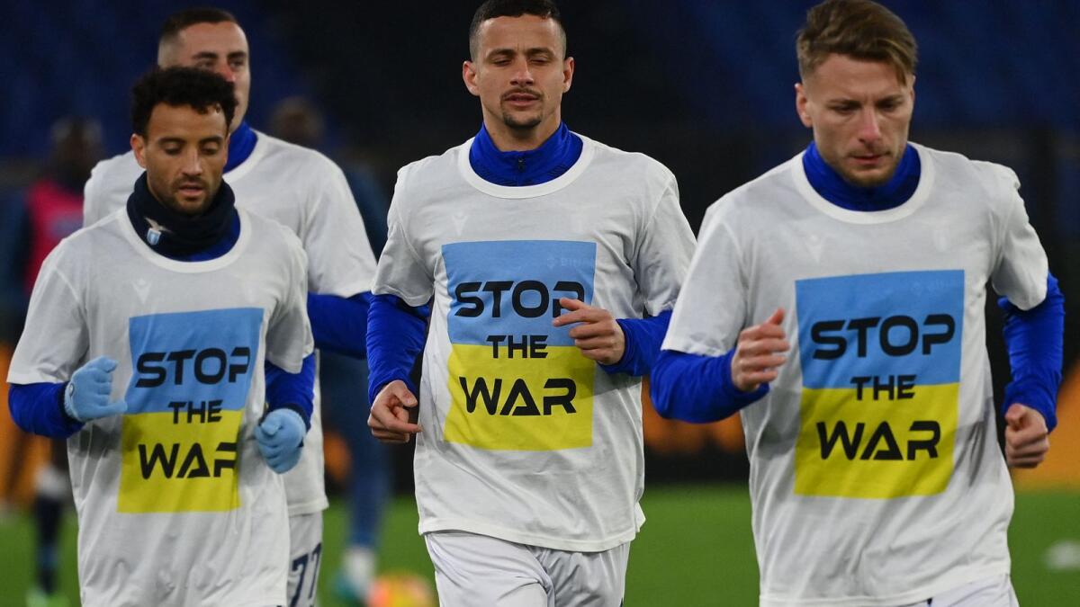 Lazio's Adam Marusic (back), Felipe Anderson (left), Luiz Felipe (second right) and Ciro Immobile warm-up wearing T-shirts with a message for peace amid the Russia’s military conflict with Ukraine. (AFP)