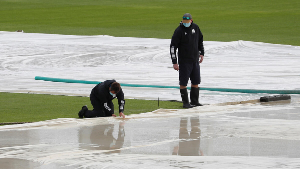 Groundstaff attend to the covers on the pitch as rain delays the start of play on the fifth and final day of the third Test match between England and Pakistan on Tuesday. - Reuters