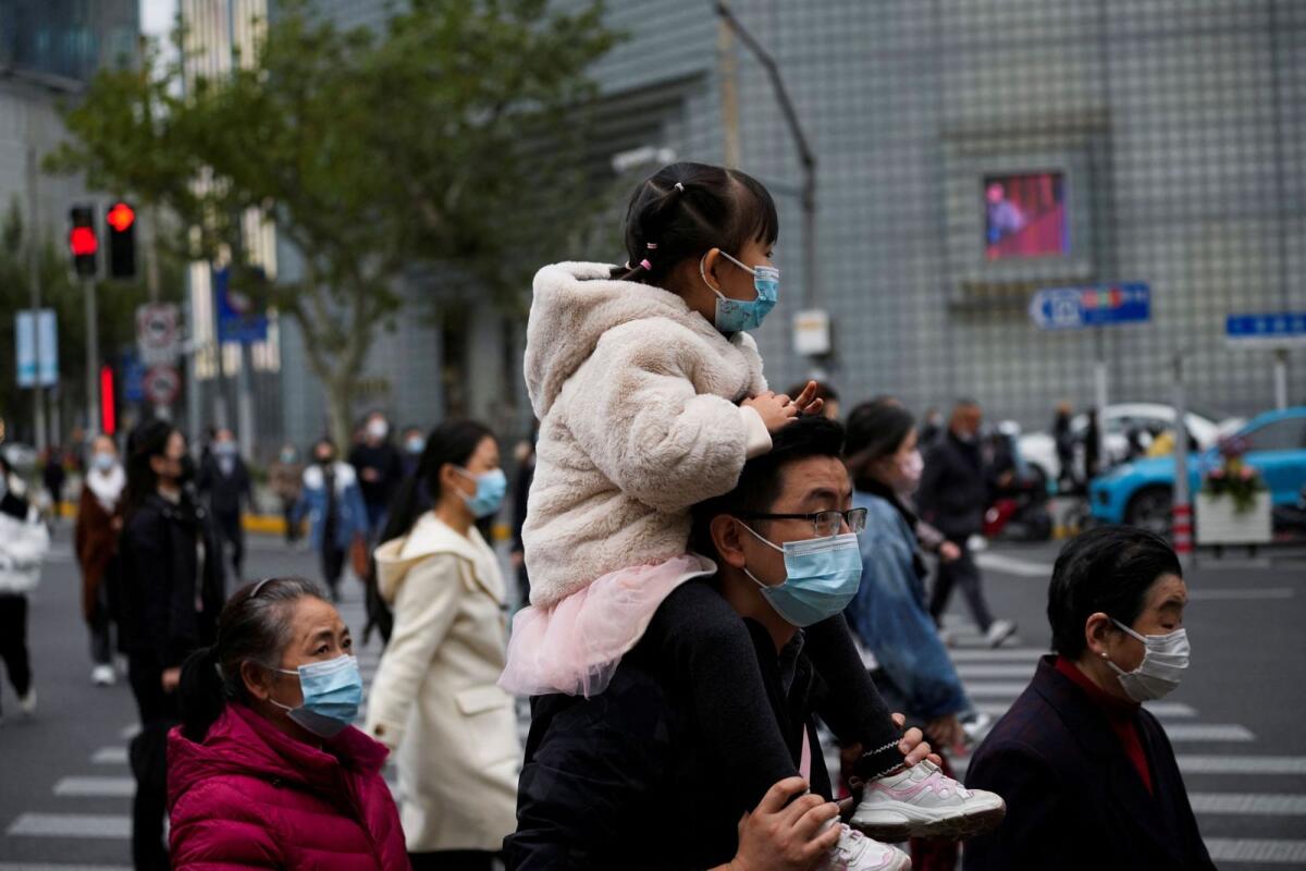 People wearing face masks cross a street, as Covid-19 outbreaks continue in Shanghai, China, on December 8, 2022. Photo: Reuters
