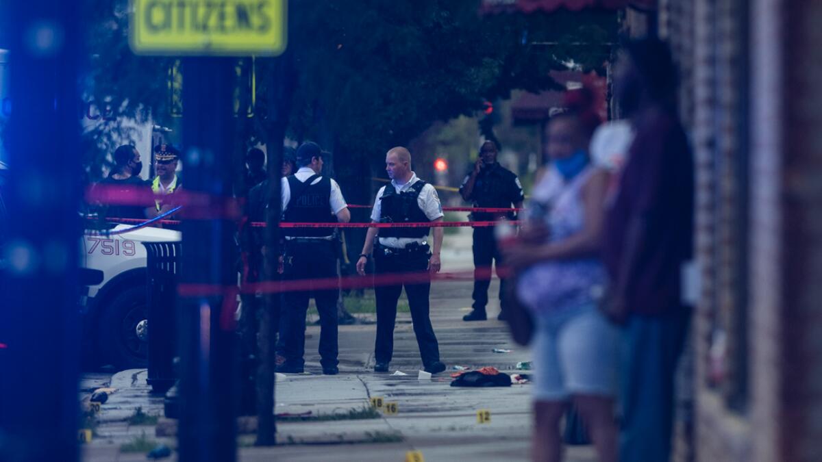 Chicago police investigate the scene of a mass shooting where more than a dozen people were shot in the Gresham neighborhood, of Chicago. Photo: AP