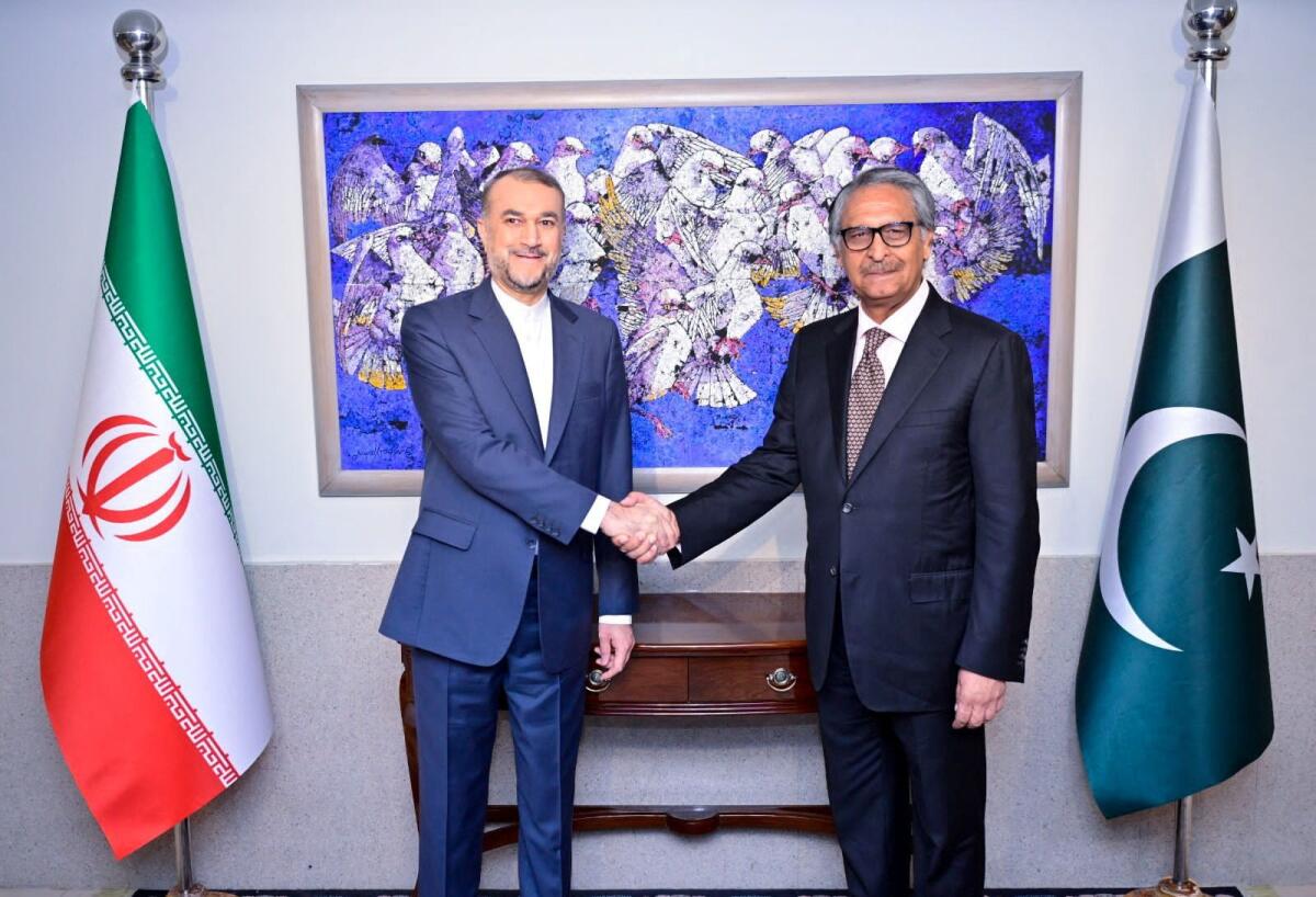 Pakistan's caretaker Foreign Minister Jalil Jilani shakes hands with Iran's Foreign Minister Hossein Amir-Abdollahian in Islamabad on Monday. — Reuters