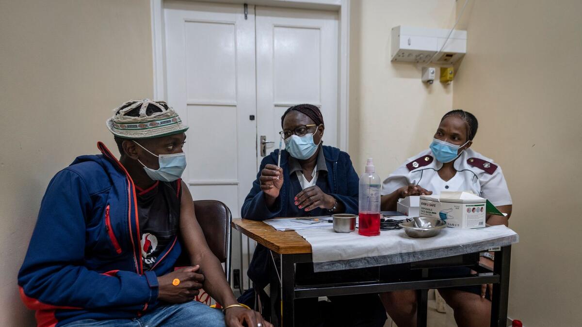 Medical staff talk to a man about to be vaccinated against Covid at the Hillbrow Clinic in Johannesburg, South Africa. – AFP