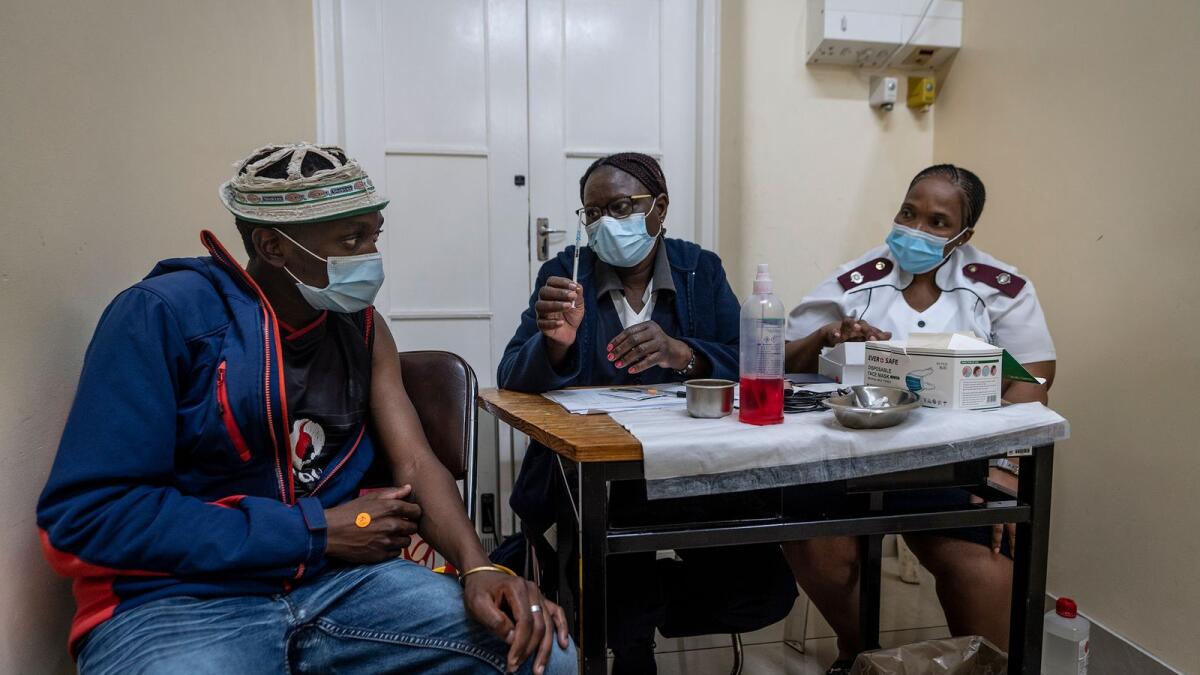 Medical staff talk to a man about to be vaccinated against Covid at the Hillbrow Clinic in Johannesburg, South Africa. – AFP