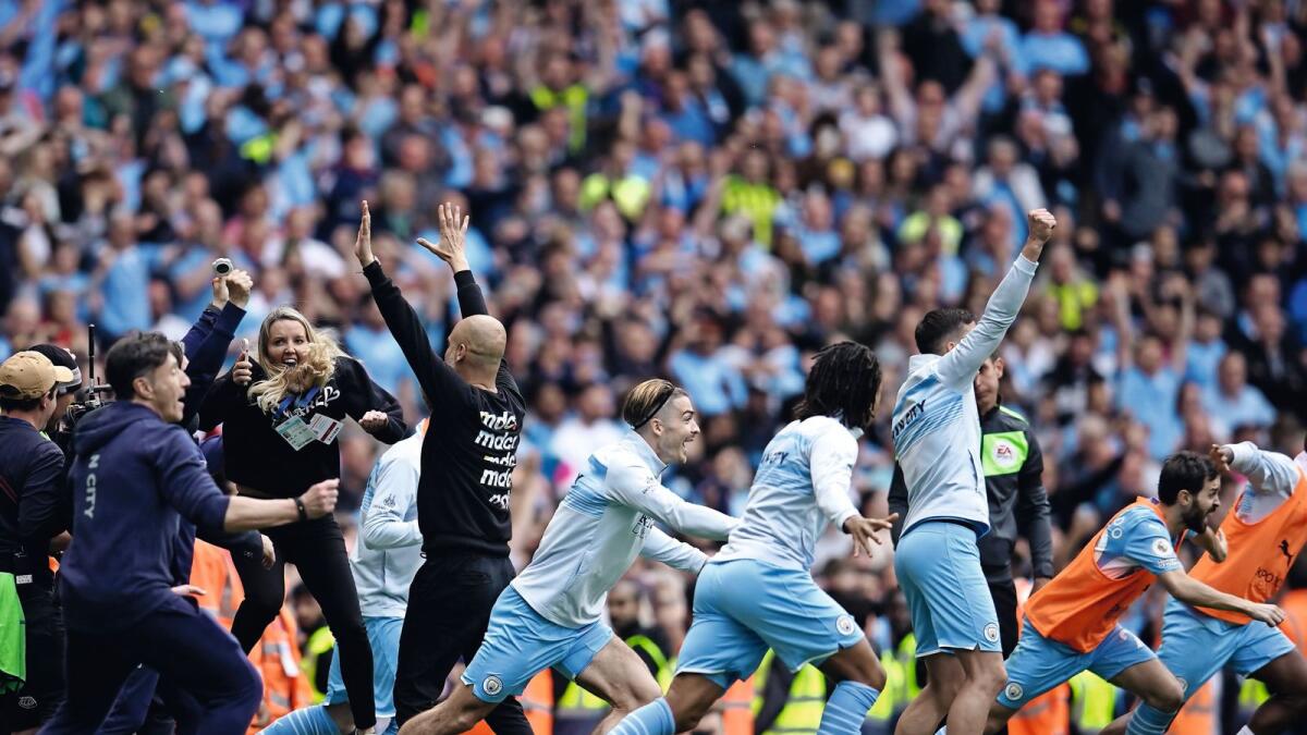 Manchester City players and staff celebrate after the final whistle. — AP